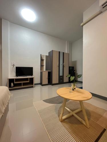 ein Wohnzimmer mit einem Tisch und einem TV in der Unterkunft พรสินี 
