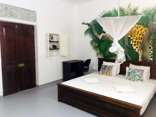 um quarto com uma cama com um quadro na parede em Anilau Vila em Hikkaduwa