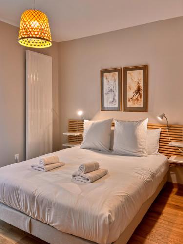 une chambre avec un grand lit avec des serviettes dessus dans l'établissement Le Manou, Appartement neuf avec terrasse, parking sous-terrain & ascenseur by PRIMO C0NCIERGERIE, à Nevers