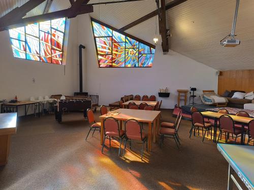 a room with tables and chairs and stained glass windows at Gästehaus Maria Rast in Suderburg