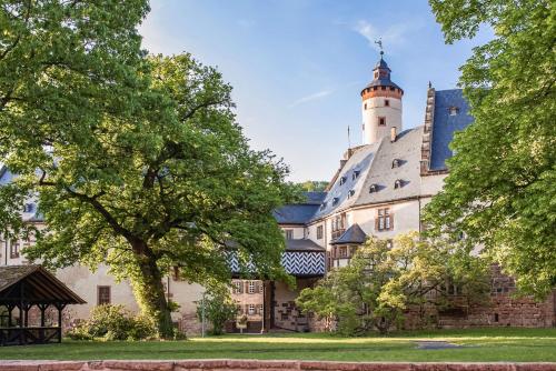 ein Schloss mit einem Leuchtturm darüber in der Unterkunft Hotel Schloss Büdingen in Büdingen