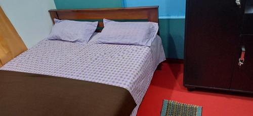 Bett mit einem Kopfteil aus Holz in einem Zimmer in der Unterkunft The Mountain Tree home in Wayanad