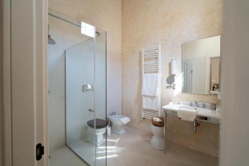y baño con ducha, aseo y lavamanos. en Palazzo Muci, en Nardò