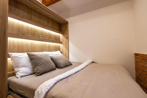a bedroom with a bed with a wooden headboard at Relax apartmán na Mlejnici in Nové Strašecí