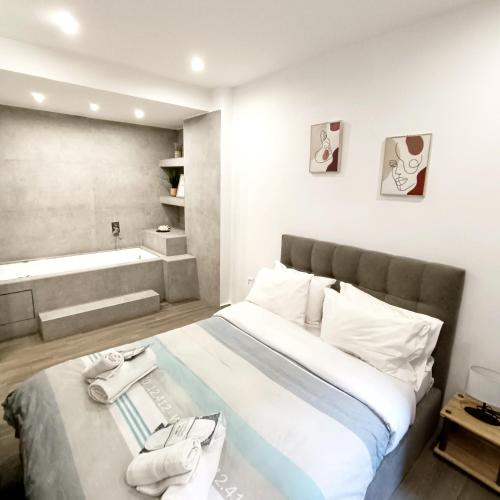 um quarto com uma cama grande e uma banheira em Navarino Jacuzzi Studio RT Hospitality Services em Tessalônica