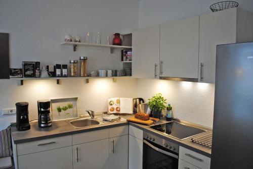 een keuken met witte kasten en een wastafel bij Ferienwohnung in der Altstadt in Bad Bevensen