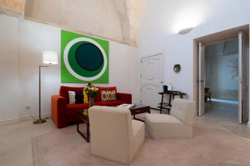 a living room with a red couch and a green wall at Palazzo Muci in Nardò