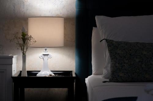 a lamp on a night stand next to a bed at Palazzo Muci in Nardò