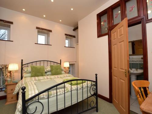 een slaapkamer met een bed met groene kussens bij 1 Bed in Ashford in the Water PK547 in Ashford