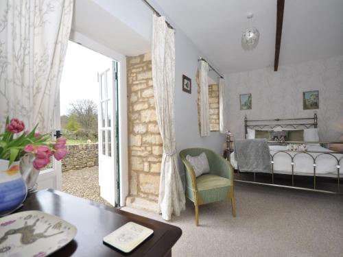 a living room with a bed and a table at 1 Bed in Bourton-on-the-Water 44960 in Withington