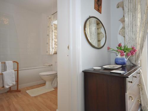 a bathroom with a toilet and a mirror on the wall at 1 Bed in Bourton-on-the-Water 44960 in Withington