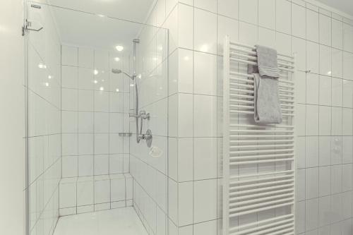 a white bathroom with a shower with a glass door at Hotel- Restaurant Einklang in Mettingen