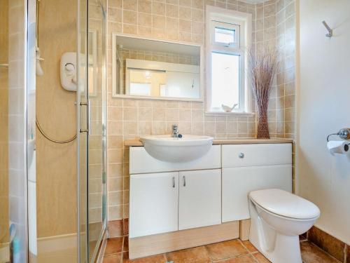 a bathroom with a toilet and a sink and a shower at 2 Bed in Charmouth 50033 in Blackpool Corner