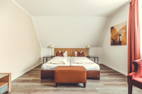MettingenにあるHotel- Restaurant Einklangのベッドと椅子のある寝室