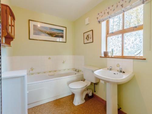 a bathroom with a toilet and a sink and a bath tub at 3 Bed in The Cairngorms 53150 in Dinnet