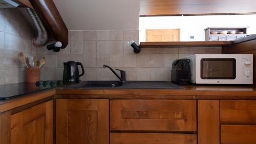 una cocina con fregadero y microondas en una encimera en Italianway - Osteglio 15 Frodolfo en Valdisotto