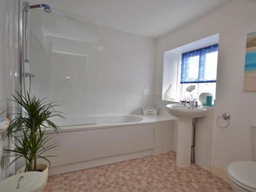 a white bathroom with a tub and a sink at 2 bed in Brixham BX021 in Brixham