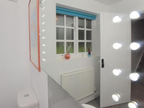 a white bathroom with a window and a sink at 2 Bed in Wroxham 56104 in Hoveton