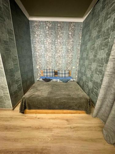 1 dormitorio con 1 cama en una habitación con papel pintado en Комфортная студия в центре города Ванадзор en Vanadzor