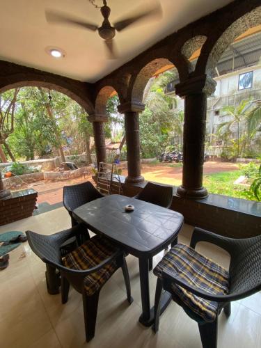 Villa Portuguese 2bhk house candolim goa في أنجونا: طاولة وكراسي في غرفة مع نافذة كبيرة
