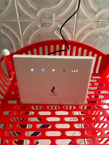 einen Laptop auf einem roten Tisch in der Unterkunft شقة الولاء Loyalty apartment in Dumyat al Jadidah