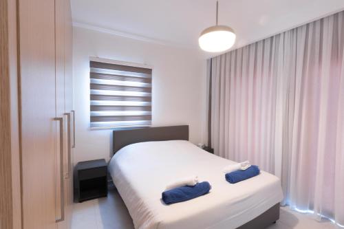 1 dormitorio con 1 cama con 2 toallas azules en Fig Tree Aqua Apartment-143 en Protaras