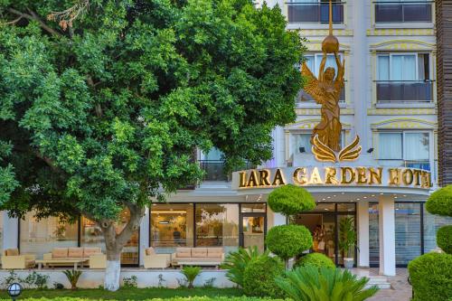 a building with a statue in front of it at Lara Garden Hotel in Lara