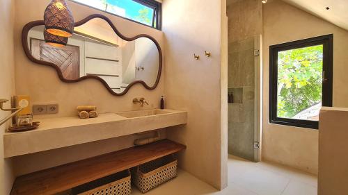 a bathroom with a sink and a mirror at Shore Thing Gili Air Beachfront Apartment in Gili Air