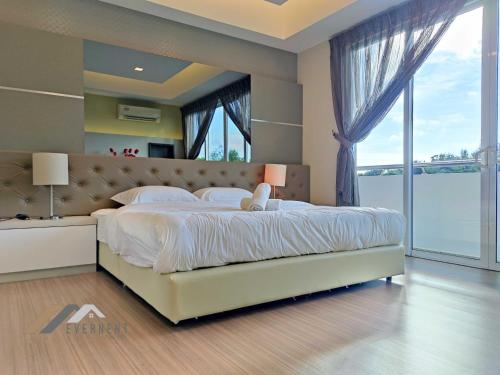 a bedroom with a large bed with a large window at Serene Heights by Evernent in Miri
