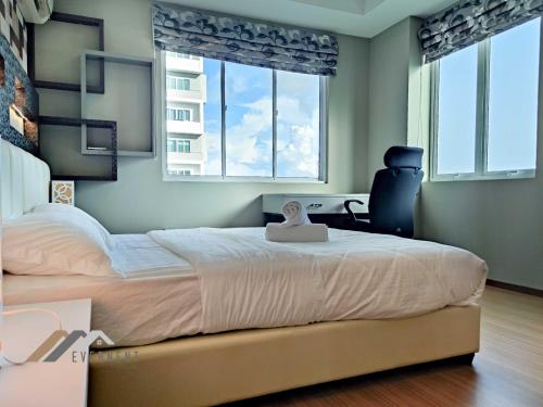 a bedroom with a large bed and two windows at Serene Heights by Evernent in Miri