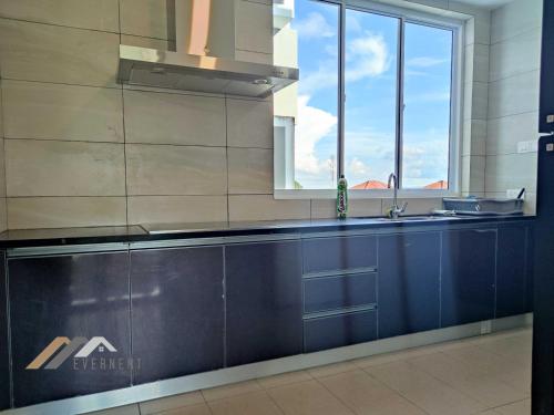 a kitchen with blue cabinets and a window at Serene Heights by Evernent in Miri