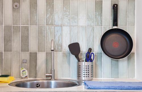 a kitchen counter with a sink with a pan and utensils at Island's Pearl in Hinkong