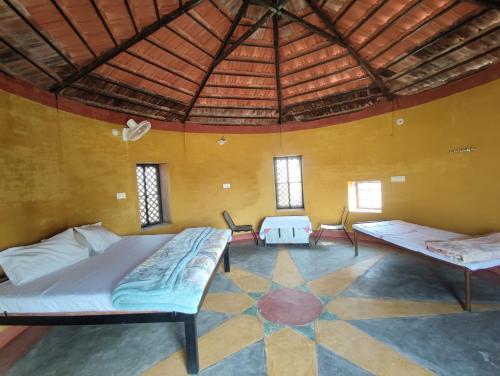 Habitación con 2 camas y mesa. en Jodhpur Farms en Jodhpur