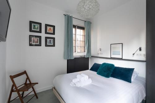 - une chambre avec un lit doté d'oreillers bleus et d'une fenêtre dans l'établissement Le Solent - Au cœur de l'intra-mutros, à Saint-Malo