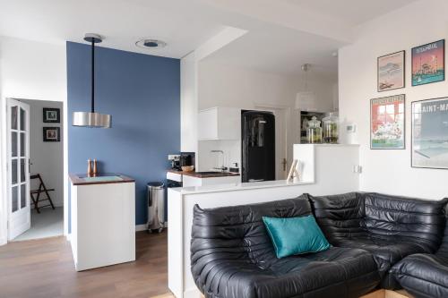 un salon avec un canapé en cuir noir dans l'établissement Le Solent - Au cœur de l'intra-mutros, à Saint-Malo