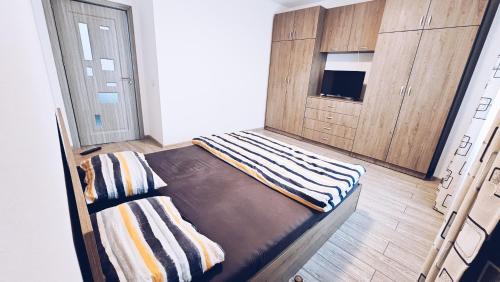 a room with a bed with a cabinet and a tv at Apartament Dem Radulescu 3 camere! in Râmnicu Vâlcea