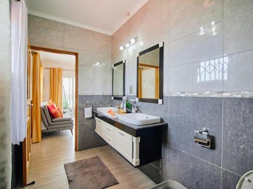 360 Degrees Villa في فيكتوريا: حمام مع حوض ومرآة