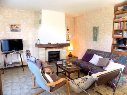 ein Wohnzimmer mit einem Sofa und einem Kamin in der Unterkunft Meschers sur Gironde - MAISON SPACIEUSE au CALME avec BEAU JARDIN ARBORE in Meschers-sur-Gironde