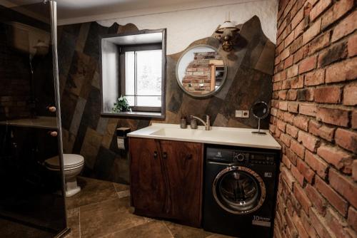 a bathroom with a sink and a washing machine at Brīvdienu māja "Saules Avoti" in Talsi