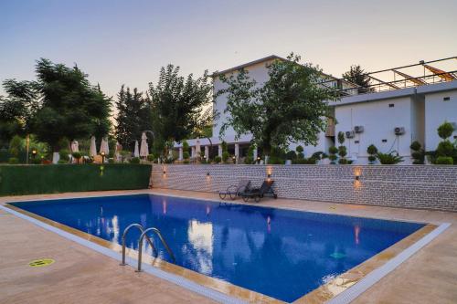 a swimming pool in front of a house at Lara Garden Hotel in Lara