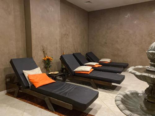 four chairs in a waiting room with orange pillows at Aspen studio Mountain retreat at Aspen Resort Golf Ski & Spa in Razlog