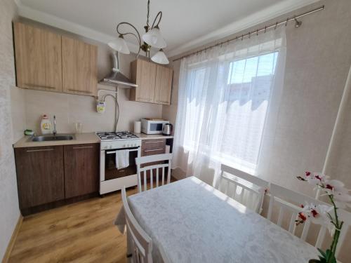 uma cozinha com uma mesa e um fogão forno superior em Riga City 2 Bedroom Lux Apartments em Riga