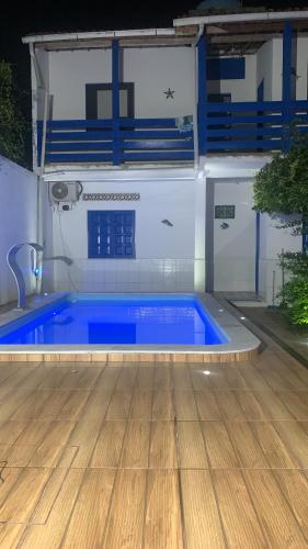 een zwembad met een houten vloer en een blauw zwembad bij Céu azul in Vera Cruz de Itaparica