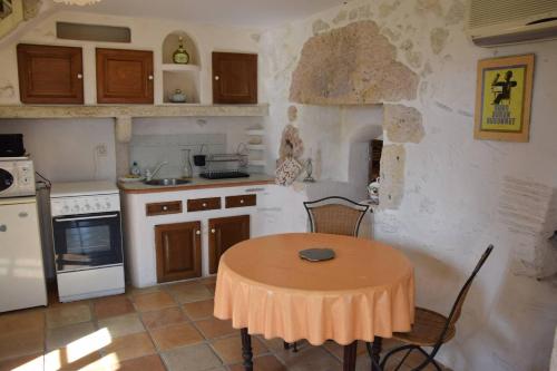 - une cuisine avec une table, une table et des chaises dans l'établissement Maison de caractère à Castella - Clévacances 3 clés, à Castella
