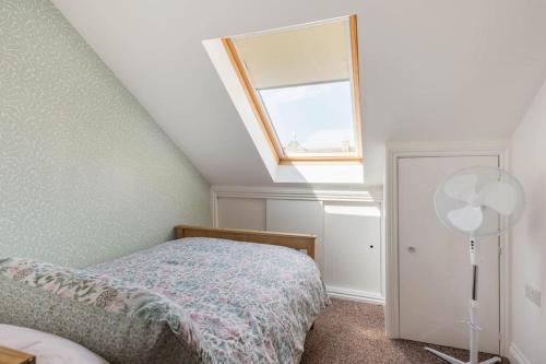 1 dormitorio con cama y ventana en Seafront flat- Private parking- Close to town en Weston-super-Mare