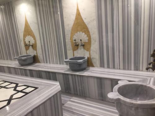 a bathroom with three urinals and a sink at MOSTAR HOTEL ANTALYA in Antalya