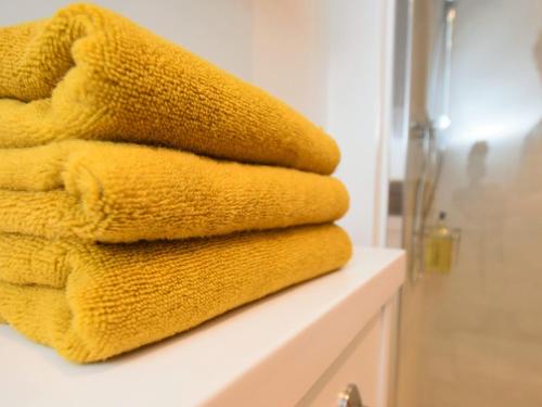 a pile of towels sitting on a counter in a bathroom at 1 Bed in Rutland Waters 60672 in Oakham