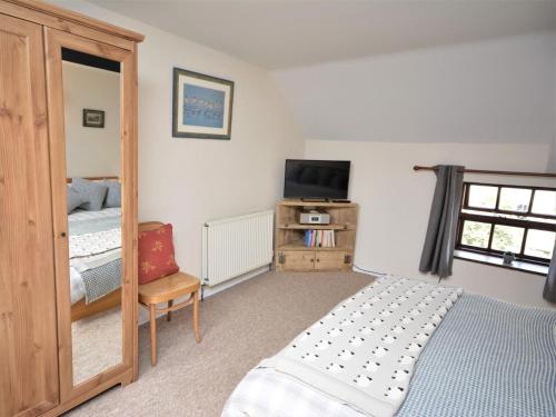 um quarto com uma cama, uma televisão e um espelho em 2 Bed in Dartmoor National Park 63337 em Spreyton