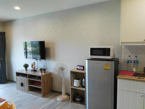 eine Küche mit einem Kühlschrank und einer Mikrowelle darüber in der Unterkunft The Beach Residence by EHM in Nai Yang Beach