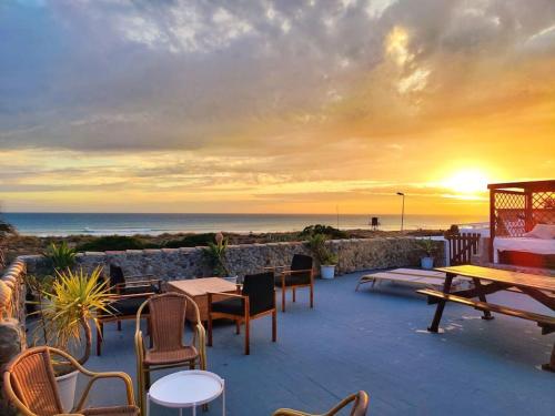 un patio con mesas y sillas y vistas al océano en La Casa de Piedra a orillas del mar, en Vejer de la Frontera